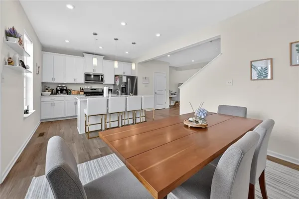 a living room with stainless steel appliances furniture a dining table and chairs