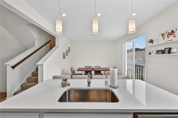 a kitchen with a sink a table and chairs