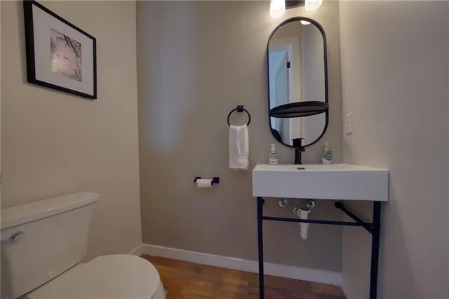 a bathroom with a toilet a sink and mirror