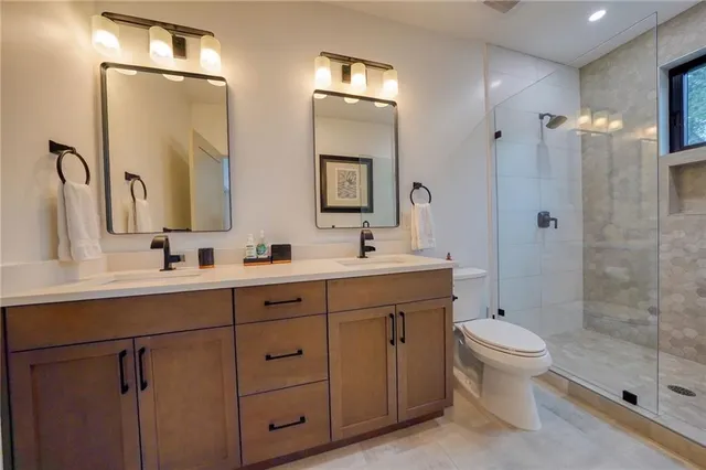 a bathroom with a double vanity sink toilet and shower