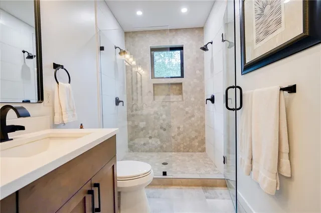 a bathroom with a sink a toilet and shower