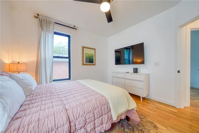 a bedroom with a bed window and a flat screen tv