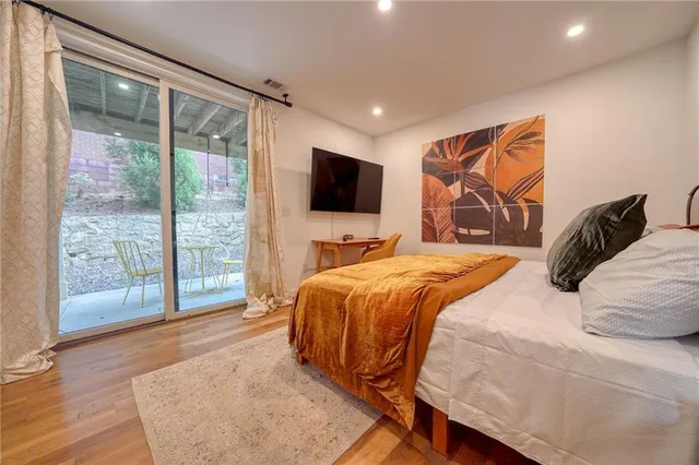 a bedroom with a large bed and a flat tv screen