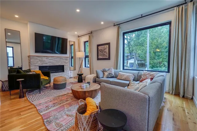 a living room with furniture a flat screen tv and a fireplace