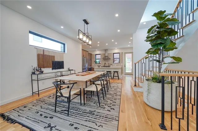 a dining room with furniture a rug and a potted plants