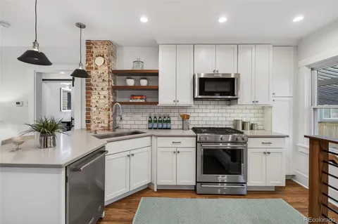 a kitchen with stainless steel appliances a stove sink microwave and cabinets