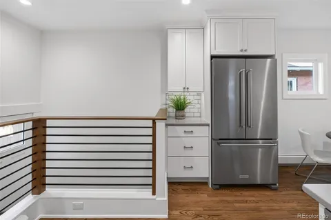 a kitchen with a refrigerator and white cabinets