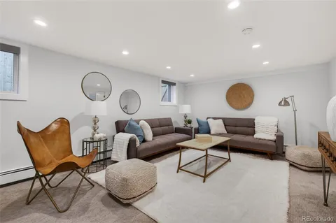 a living room with furniture a rug and white walls