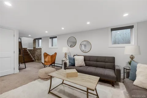 a living room with furniture kitchen view and a window