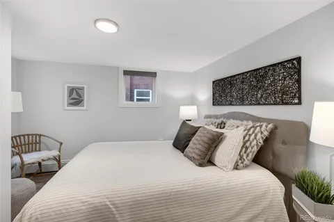 a bedroom with a bed and a painting on the wall
