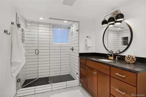 a bathroom with a sink a mirror and shower