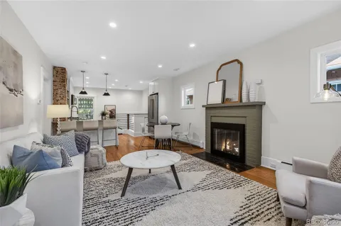 a living room with furniture a rug a fireplace and a window