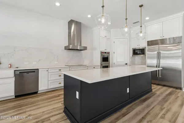 a kitchen with white cabinets stainless steel appliances and sink