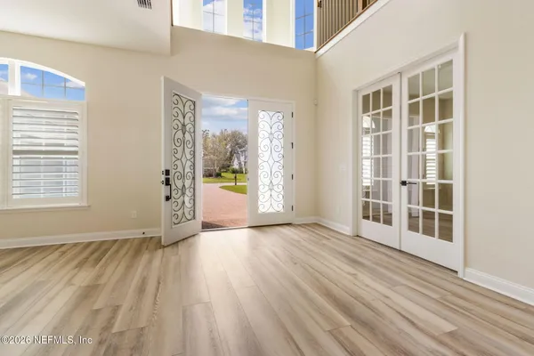 an empty room with wooden floor and windows