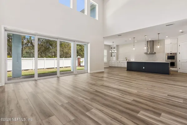 a large kitchen with kitchen island a stove a sink a center island and wooden floor