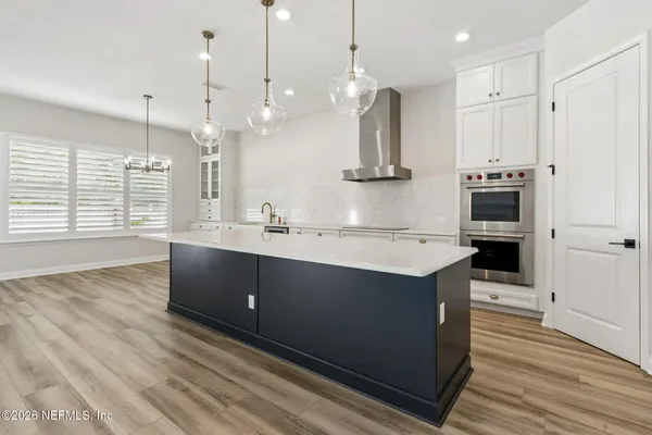 a large kitchen with stainless steel appliances kitchen island a large counter top a sink a stove and a refrigerator