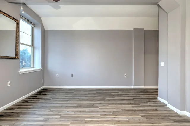 a view of a room with wooden floor and windows