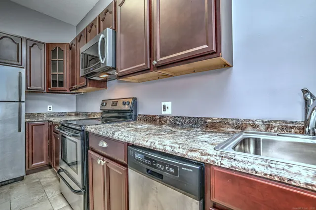 a kitchen with stainless steel appliances granite countertop a sink stove and cabinets