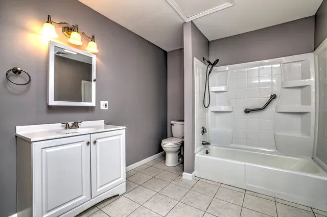 a bathroom with a tub a sink and mirror