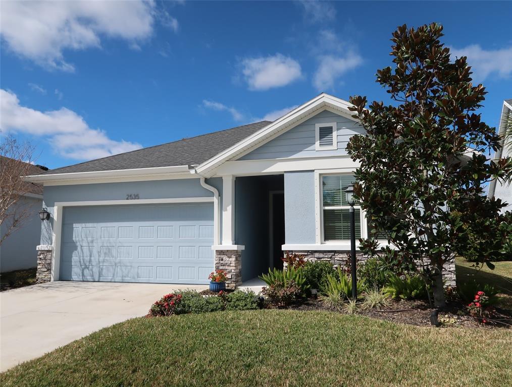 a front view of a house with a yard and garage