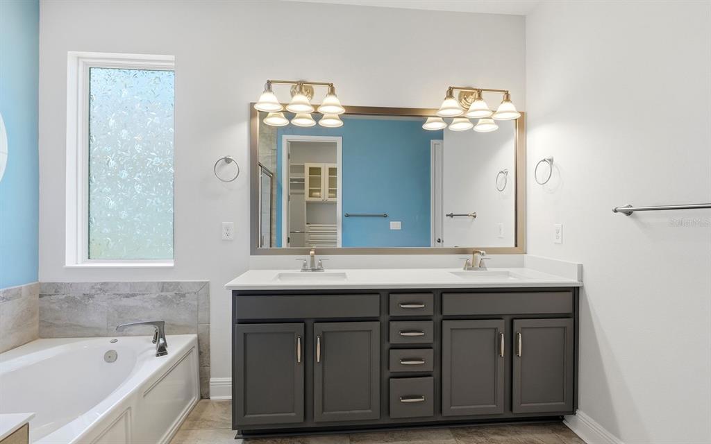 2535 Fireflag Lane Sarasota, FL 34232 - Photo 21 of 27 a bathroom with a double vanity sink and a bathtub
