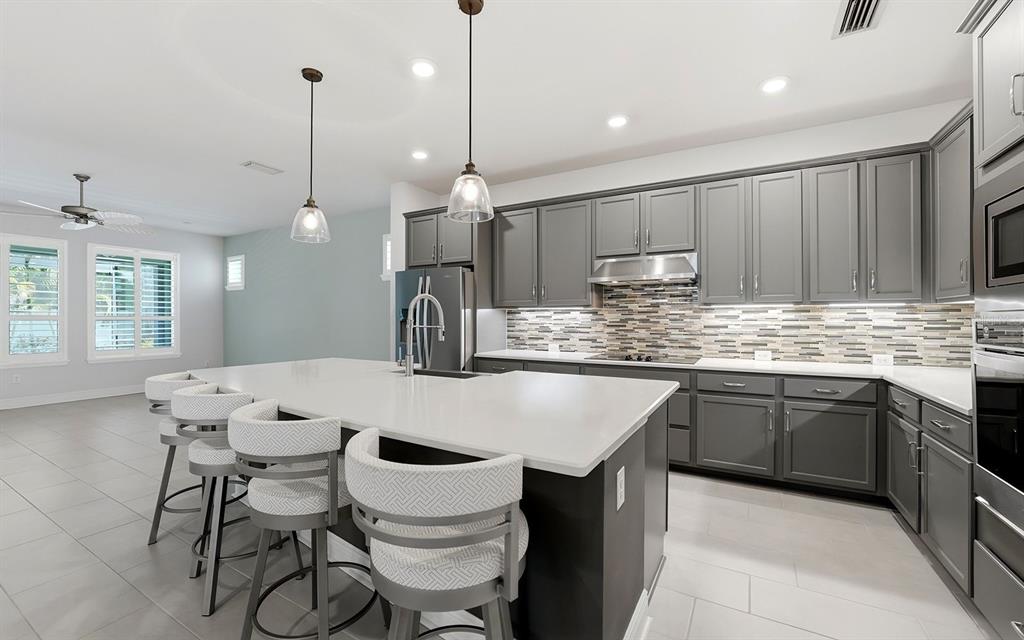 2535 Fireflag Lane Sarasota, FL 34232 - Photo 4 of 27 a kitchen with a table chairs sink and cabinets