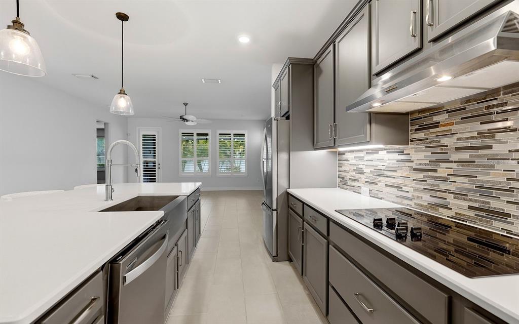 2535 Fireflag Lane Sarasota, FL 34232 - Photo 6 of 27 a kitchen with stainless steel appliances granite countertop a sink a stove and a wooden floors