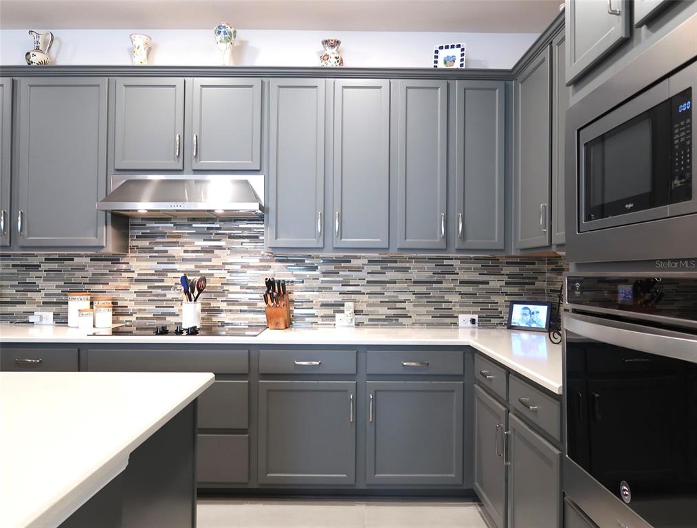2535 Fireflag Lane Sarasota, FL 34232 - Photo 6 of 17 a kitchen with stainless steel appliances granite countertop a sink stove and microwave