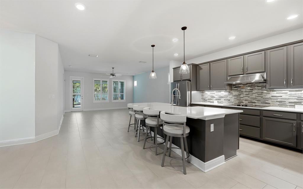 2535 Fireflag Lane Sarasota, FL 34232 - Photo 7 of 27 a kitchen with stainless steel appliances kitchen island granite countertop a sink a counter space and cabinets