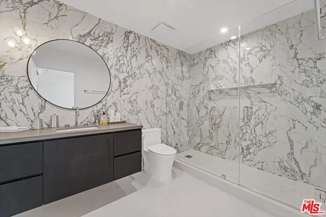 a bathroom with a sink a toilet and a mirror