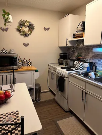 a kitchen with a white stove top oven and cabinets