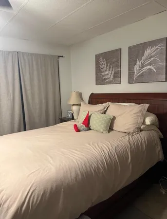 a bedroom with a bed and painting on the wall