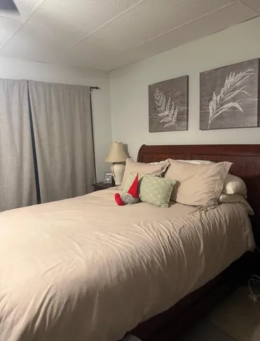 a bedroom with a bed and painting on the wall