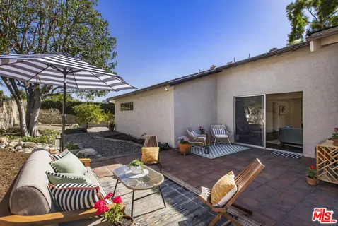 a front view of a house with a yard and mountain view in back