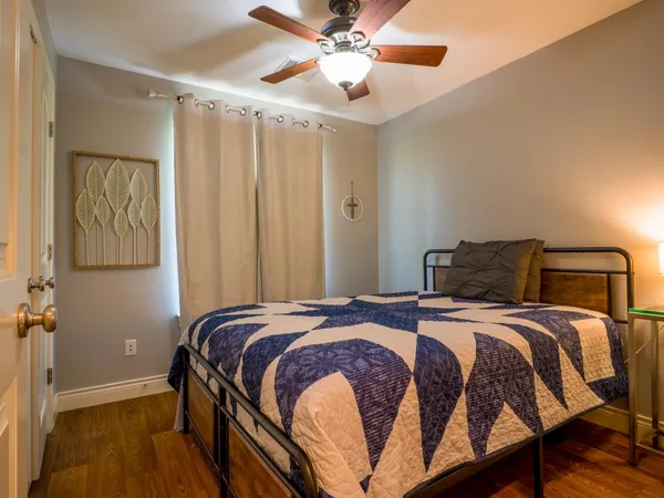a bedroom with a bed and wooden floor