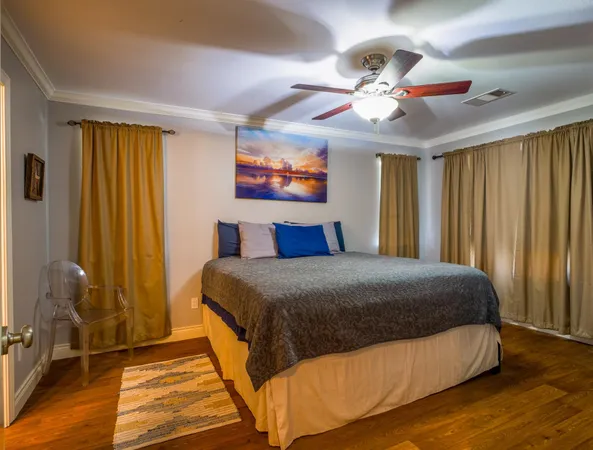 a bedroom with a large bed and a chandelier