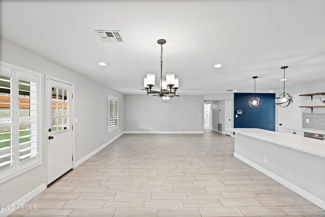 a kitchen with stainless steel appliances a stove a sink a microwave a refrigerator a stove and white cabinets