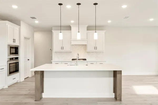 a bathroom with a granite countertop sink a toilet a mirror a bathtub and shower