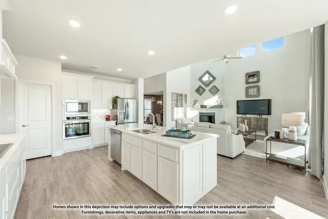 a open kitchen with stainless steel appliances granite countertop a stove oven and a refrigerator with white cabinets