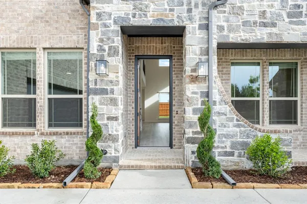 an empty room with wooden floor chandelier and windows