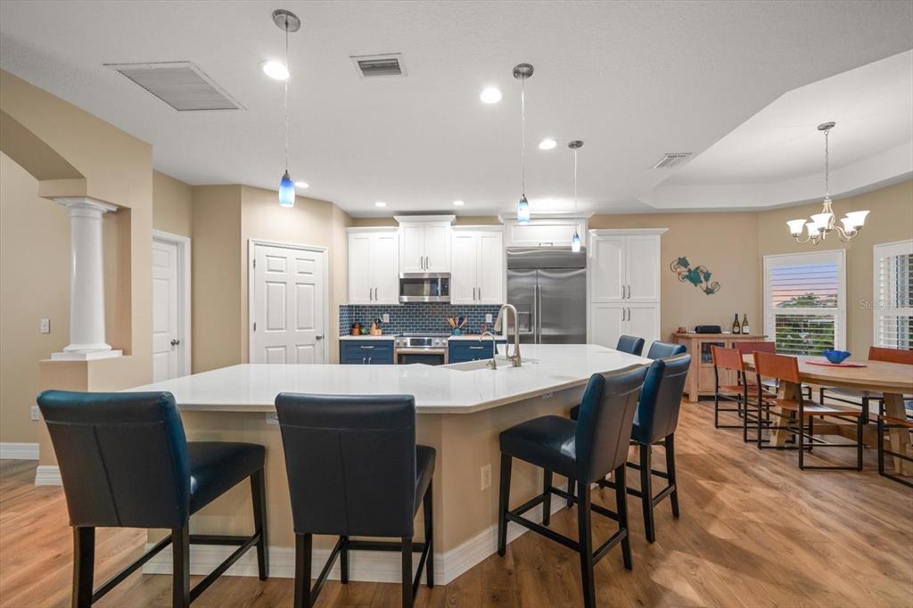 3339 Seaway Drive New Port Richey, FL 34652 - Photo 22 of 48 a dining room with stainless steel appliances kitchen island granite countertop a dining table chairs and a refrigerator