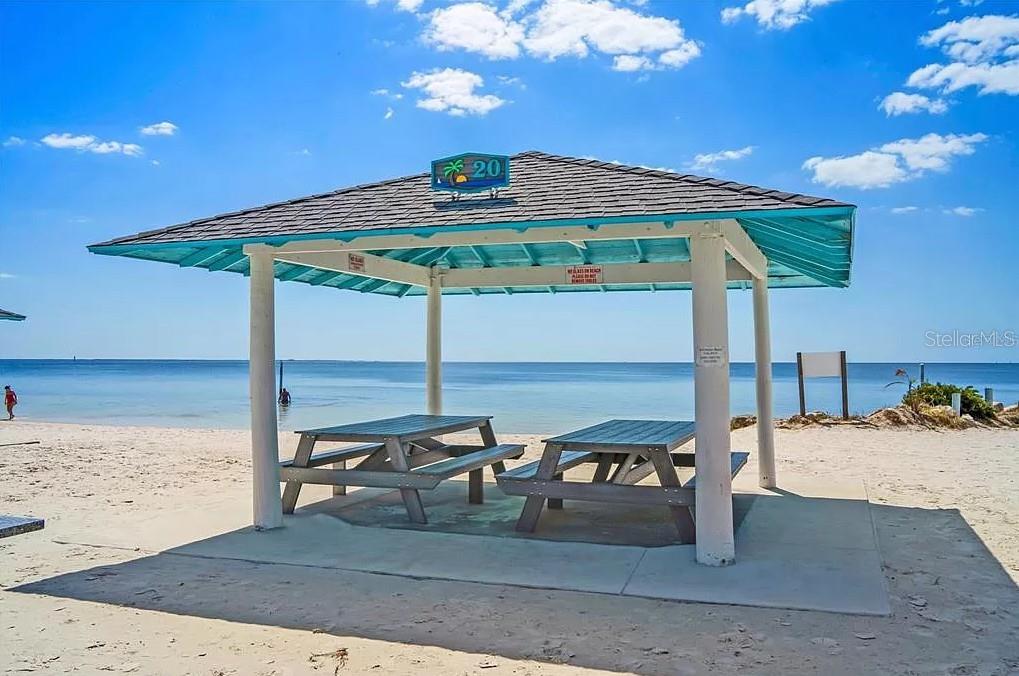 3339 Seaway Drive New Port Richey, FL 34652 - Photo 47 of 48 a roof deck with table and chairs under an umbrella with large trees