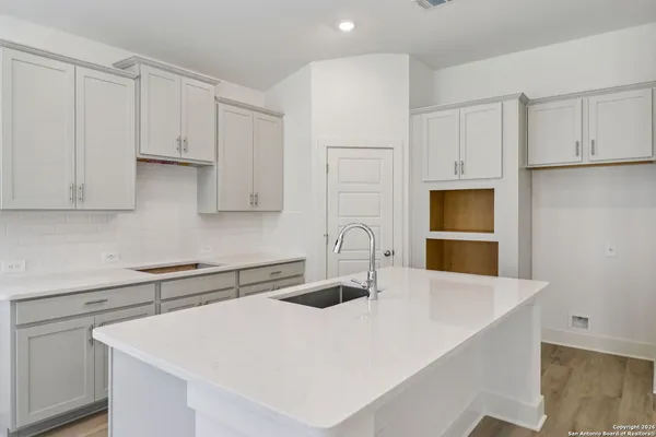 a kitchen with stainless steel appliances a sink a stove and white cabinets