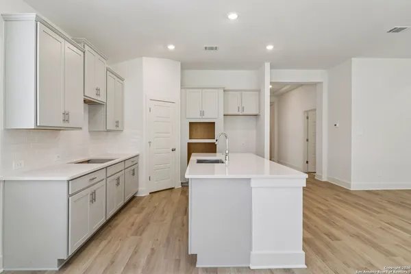 a kitchen with white cabinets appliances and sink