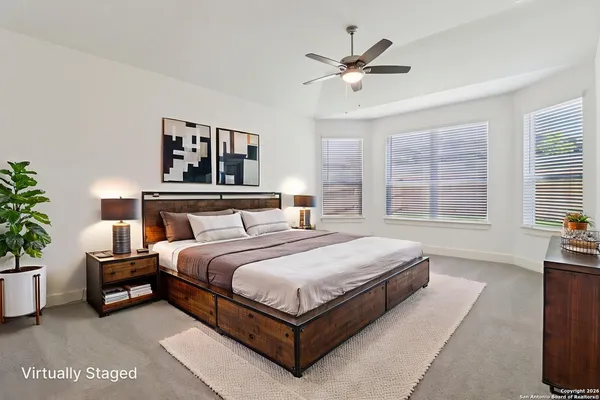 a bedroom with a large bed and a potted plant