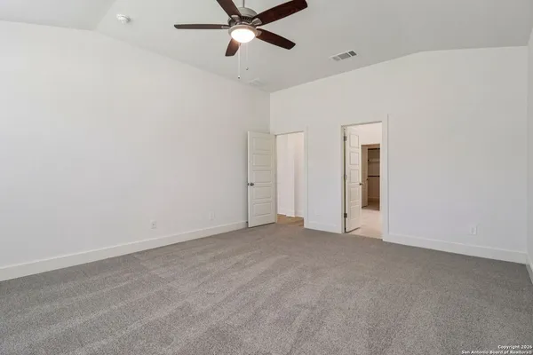 a view of an empty room with a ceiling fan
