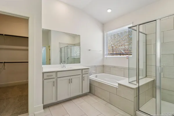 a bathroom with a tub sink and mirror
