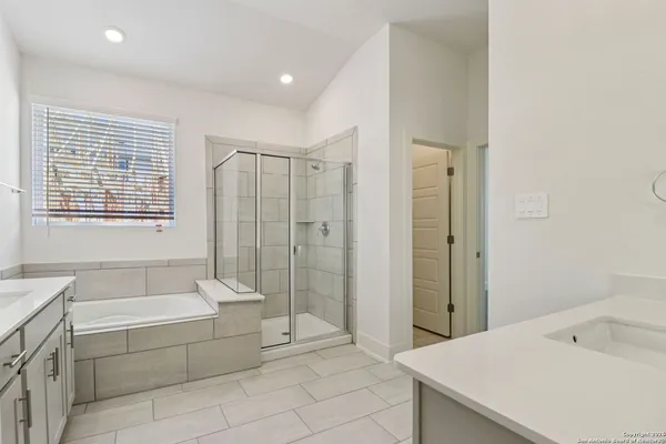 a spacious bathroom with a tub shower and sink