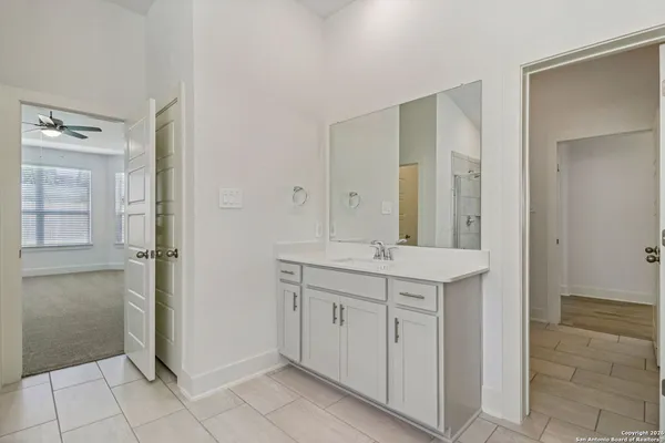 a spacious bathroom with a granite countertop sink a mirror and a vanity