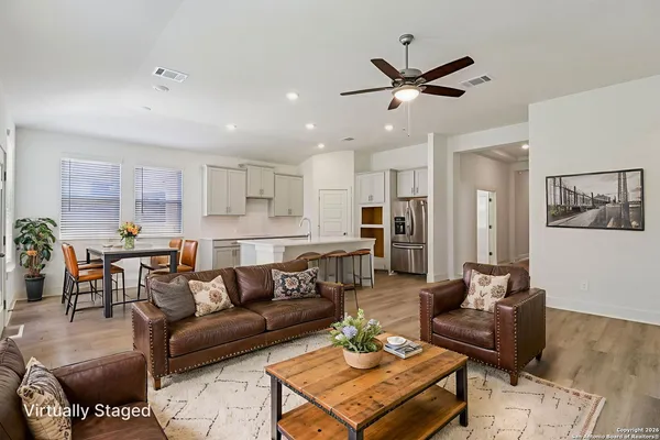 a living room with furniture kitchen view and a chandelier